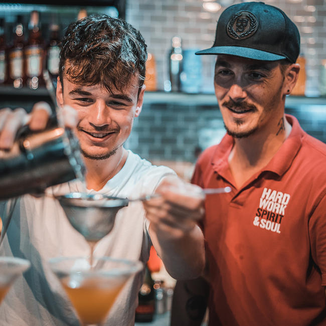 instructor teaching student straining cocktail